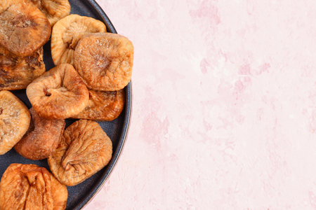 Plate with sweet dried figs on pink backgroundの写真素材