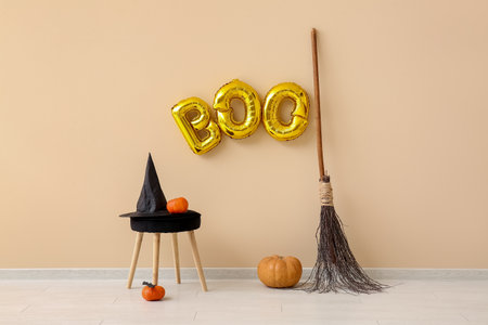 Stool and text BOO made of balloons hanging on beige wall in living roomの写真素材