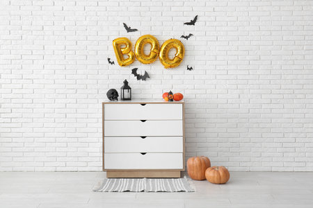 Text BOO made of balloons on light brick wall in living roomの写真素材