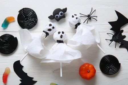 Composition with tasty lollipops and Halloween decor on light wooden backgroundの写真素材
