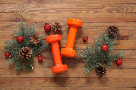 Composition with dumbbells, fir branches and Christmas decorations on wooden backgroundの写真素材