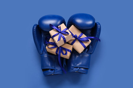 Boxing gloves and Christmas gifts on blue backgroundの写真素材