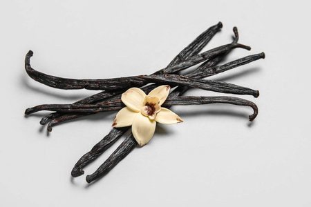 Aromatic vanilla sticks and flower on gray background