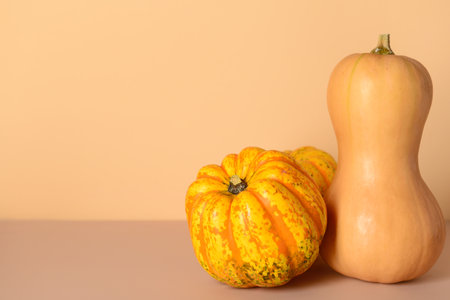 Different fresh pumpkins on beige backgroundの写真素材