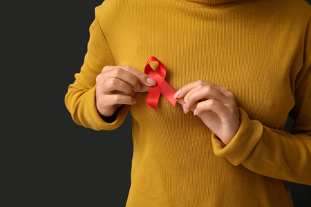 Woman with red ribbon on black background. World AIDS Day conceptの写真素材