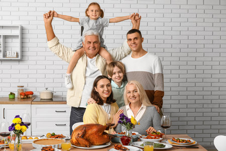 Happy family having dinner at festive table on Thanksgiving Dayの写真素材