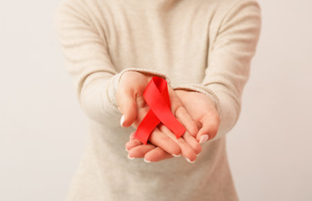 Woman with red ribbon on white background. World AIDS Day conceptの写真素材