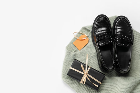 Stylish female shoes, sweater and gift box on white background. Black Friday saleの写真素材