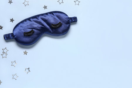 Composition with sleep mask, false eyelashes and stars on color backgroundの写真素材