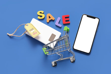 Modern gadgets, shopping cart and tag on color background. Cyber Monday sale