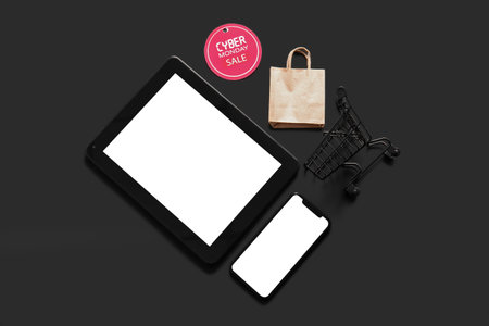Modern gadgets and tag with text CYBER MONDAY SALE on black background