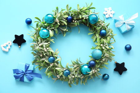 Christmas mistletoe wreath with balls and gift boxes on blue backgroundの写真素材