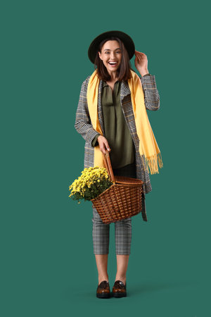 Young woman with chrysanthemum flowers on green backgroundの写真素材