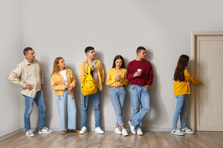People standing in line near light wall