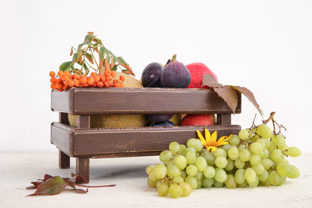 Wooden box with different fresh fruits on white backgroundの写真素材