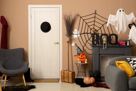 Interior of festive living room with Halloween decorations, fireplace and gray armchairの写真素材