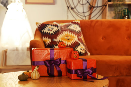 Coffee table with Halloween gift boxes and pumpkins in living room, closeupの写真素材