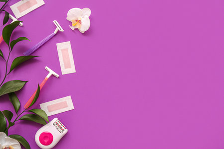Safety razors with wax strips, plant branches and modern epilator on purple backgroundの写真素材