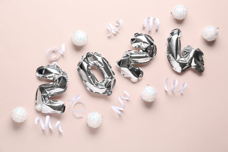 Figure 2024 made of balloons with Christmas balls and ribbons on beige backgroundの写真素材