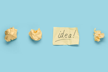 Crumpled paper and card with word IDEA on blue background. Business idea conceptの写真素材
