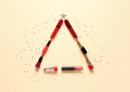 Christmas tree made of makeup products and decor on orange backgroundの写真素材