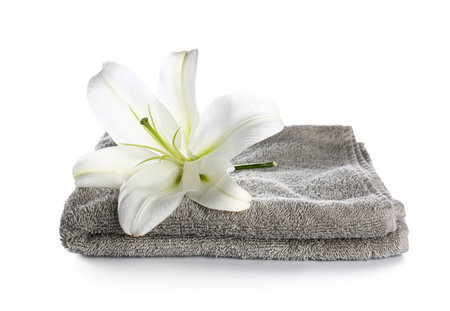 Clean towel and beautiful lily flower on white backgroundの写真素材