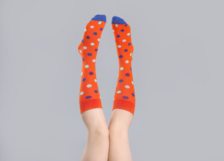 Legs of young woman in socks on gray backgroundの写真素材