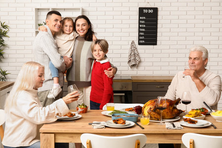 Happy family having dinner at festive table on Thanksgiving Dayの写真素材