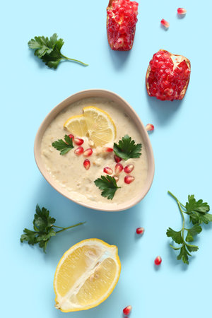 Bowl of tasty baba ghanoush on blue backgroundの写真素材