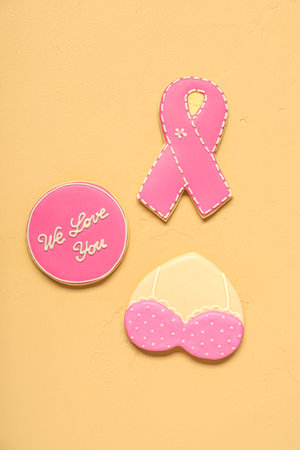 Pink cookies with ribbon, bra and supportive words on beige background. Breast cancer awareness conceptの写真素材