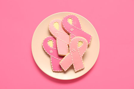 Plate with cookies in shape of pink ribbon on color background. Breast cancer awareness conceptの写真素材
