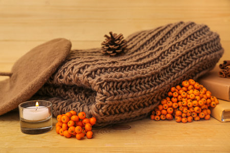 Composition with stylish female clothes, burning candle and natural forest decor on wooden background, closeupの写真素材