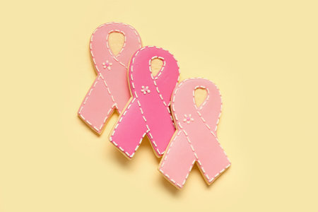 Cookies in shape of pink ribbon on yellow background. Breast cancer awareness conceptの写真素材