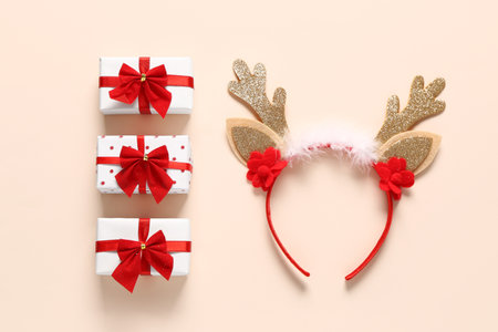 Christmas reindeer horns with gift boxes on beige backgroundの写真素材