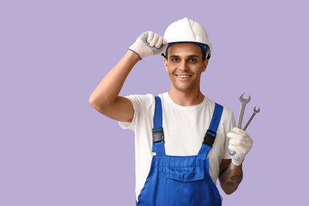 Male car mechanic with wrenches on lilac backgroundの写真素材