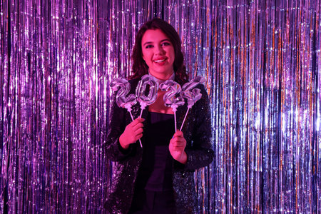 Young woman with figure 2024 against shiny tinsel