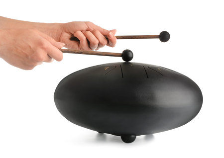 Female hands with sticks playing glucophone on white background