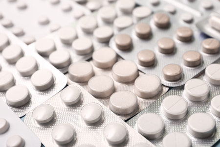 Blister packs with white pills as background