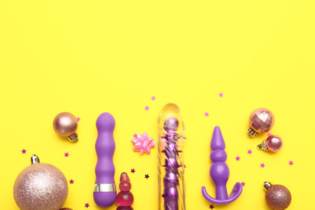 Sex toys and Christmas balls on yellow backgroundの写真素材