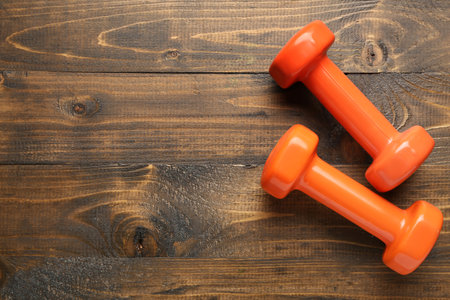 Orange dumbbells on wooden backgroundの写真素材