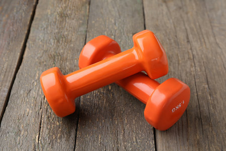 Orange dumbbells on wooden backgroundの写真素材