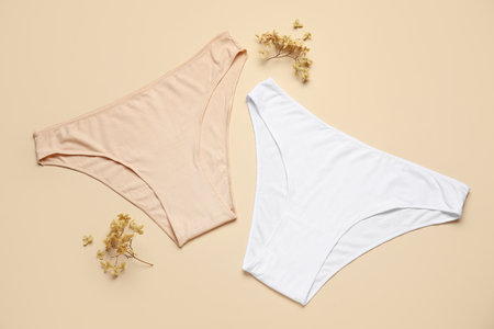 Cotton female panties and dried flowers on color backgroundの写真素材