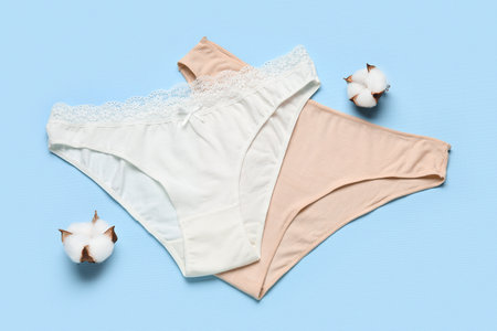 Female panties and cotton flowers on color backgroundの写真素材