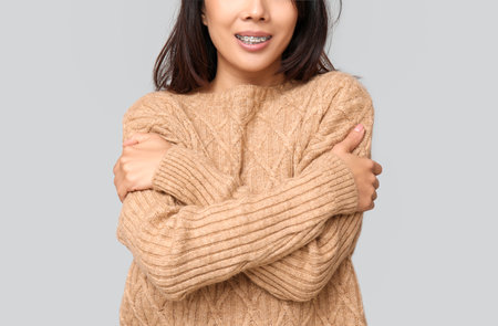 Young woman hugging herself on light background, closeupの写真素材