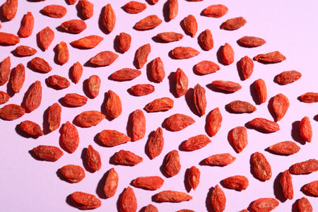 Red dried goji berries on lilac background
