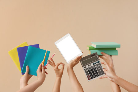 Women with blank tablet computer, books and calculator on beige backgroundの写真素材