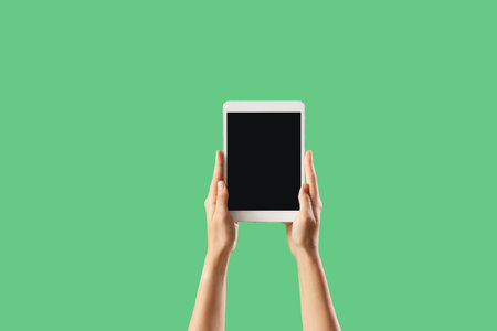 Woman with blank tablet computer on green background