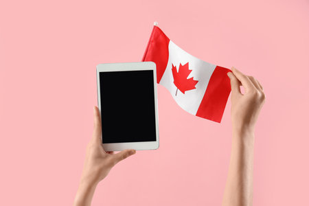 Woman with blank tablet computer and Canadian flag on pink backgroundの写真素材