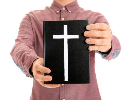 Young man with Bible isolated on white background, closeupの写真素材