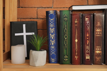 Bible with houseplant and candle on shelving unit in living room, closeupの写真素材